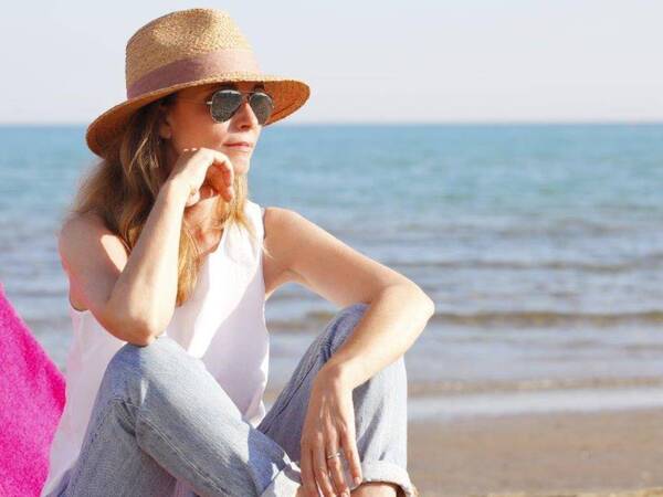 A woman enjoys a sunny day at the beach shortly after recovery from robotic hysterectomy.