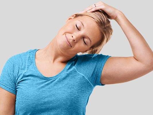 A model tilts her head toward her left shoulder, representing easy stretches for neck and back pain.