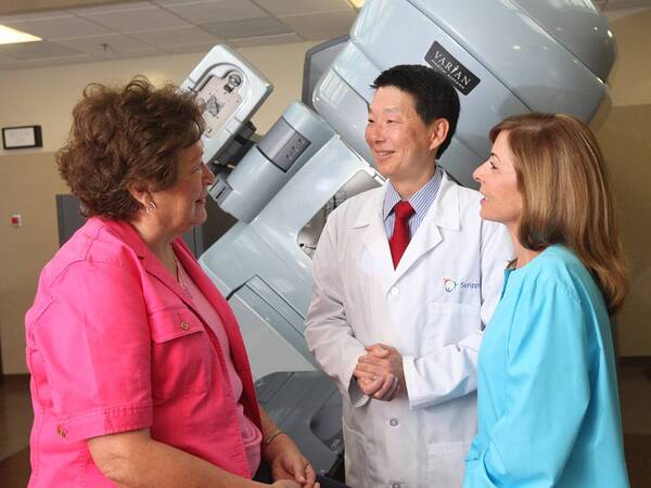 Ray Lin, MD, discusses radiation therapy with a breast cancer patient.