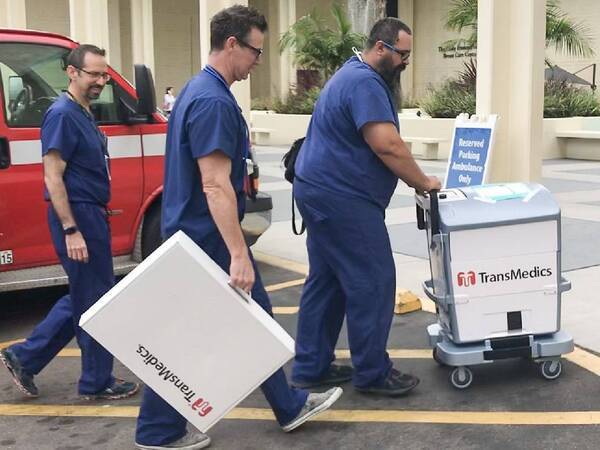 Three medical workers transport a liver that is to be donated for transplant.
