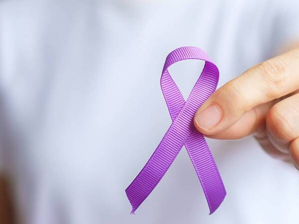 A person shows off a purple ribbon representing support for testicular cancer.
