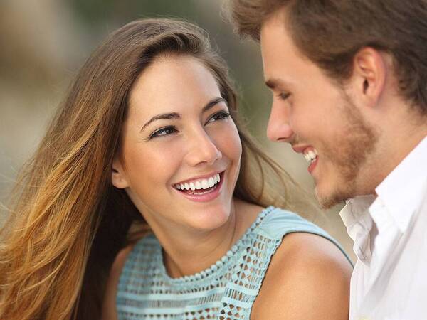 A happy young couple smiling at each other.