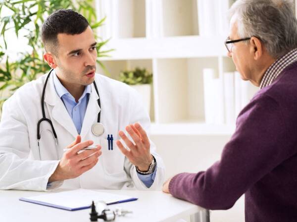 A physician discusses treatment with aortic aneurysm patient.
