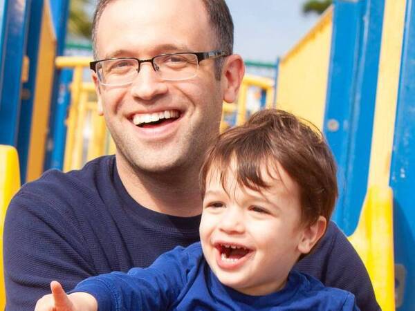 Leonard Sokol, MD, sits at the playground with his son. 
