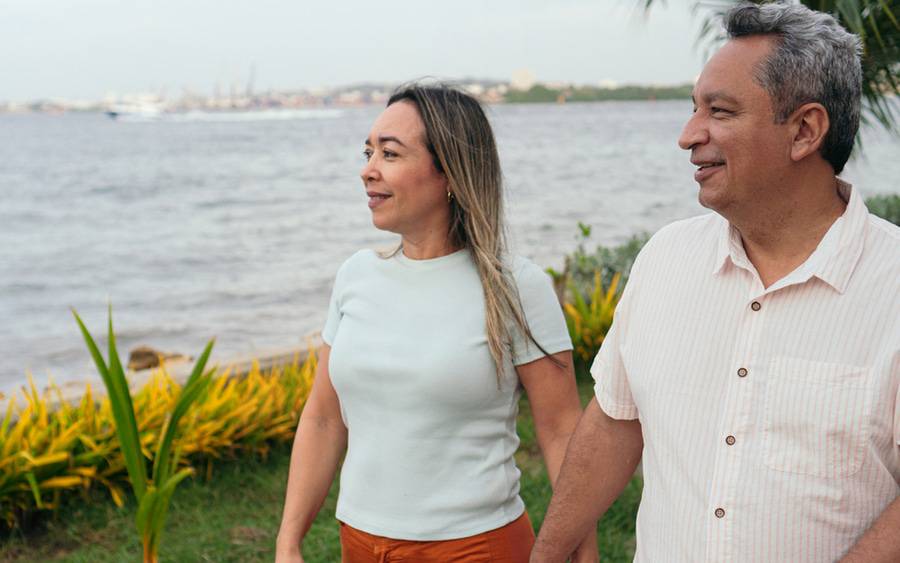 An older couple enjoy a stroll by the water with less back pain thanks to a new minimally invasive procedure.