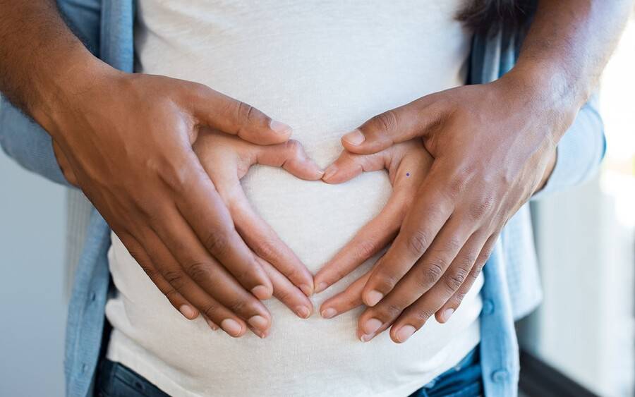 A pregnant woman with preeclampsia is held by her spouse.