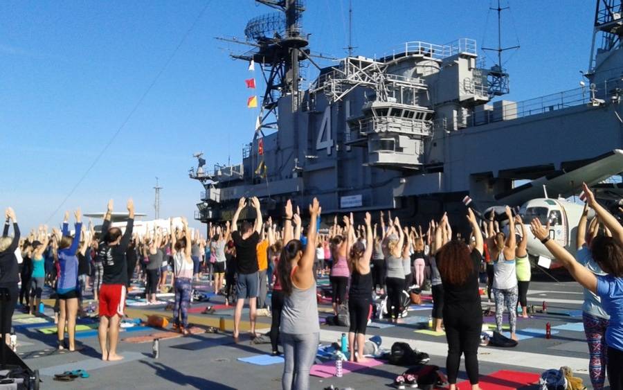Men and women doing yoga on the USS Midway