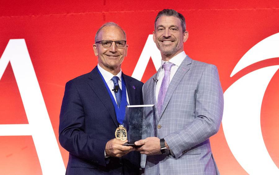 Gregory Mundis, MD, (right) receiving the AAOS 2026 Humanitarian Award during the group’s annual conference in New Orleans. Courtesy of AAOS 