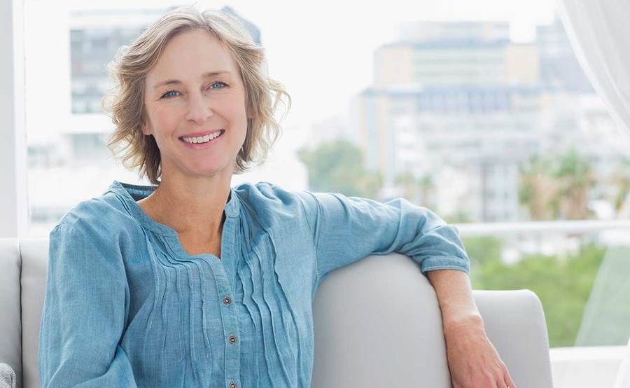 A smiling middle-aged woman represents the full life that can be led after adrenal cancer treatment.