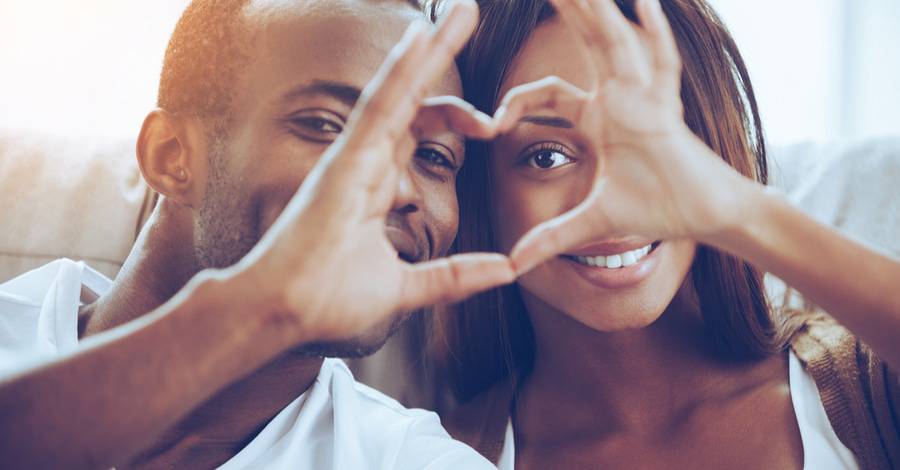 An African-American couple make a sign of a heart to signify their love for each other on Valentine's Day.