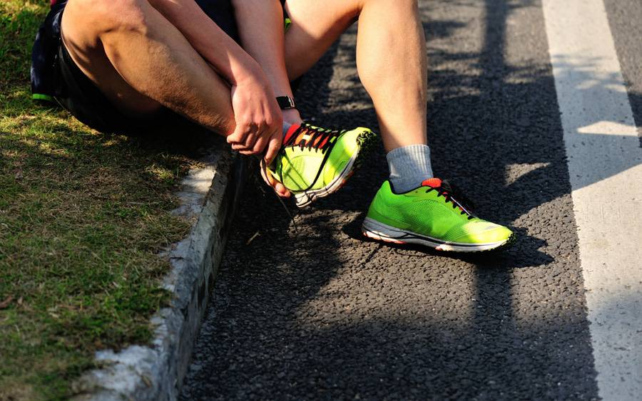 A man sits after turning his ankle while running. Could it be a sprain, a strain or a fracture?