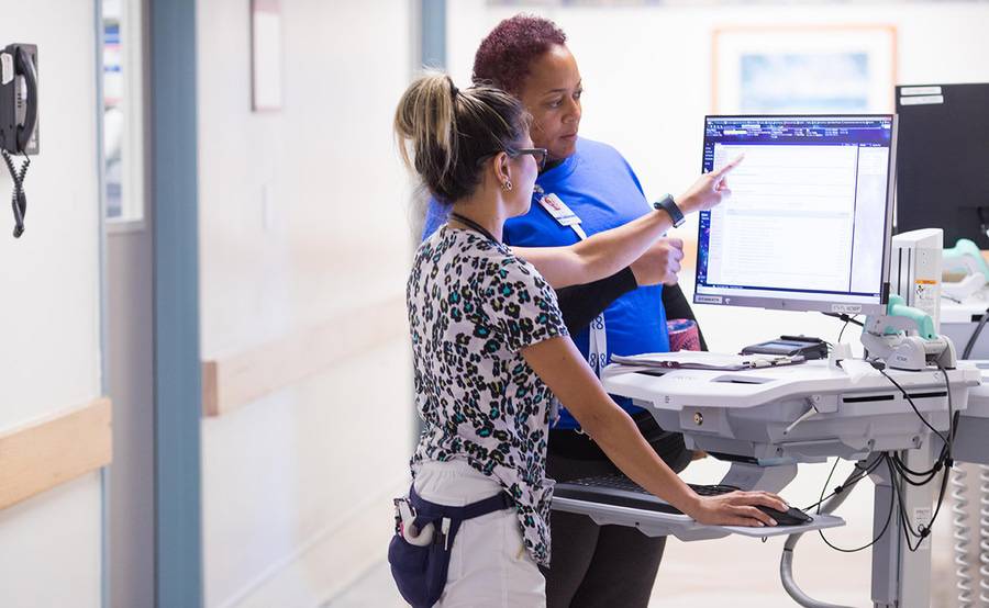 Two nurses at Scripps Health in San Diego reviewing patient care information and working together to bring the best possible care to their patients. 