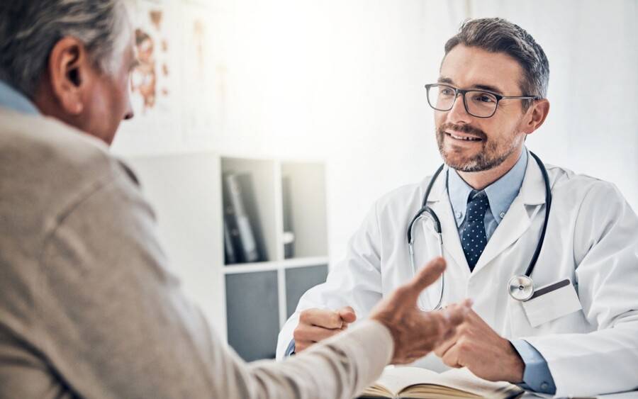 An older man consults with his doctor during his annual physical exam.