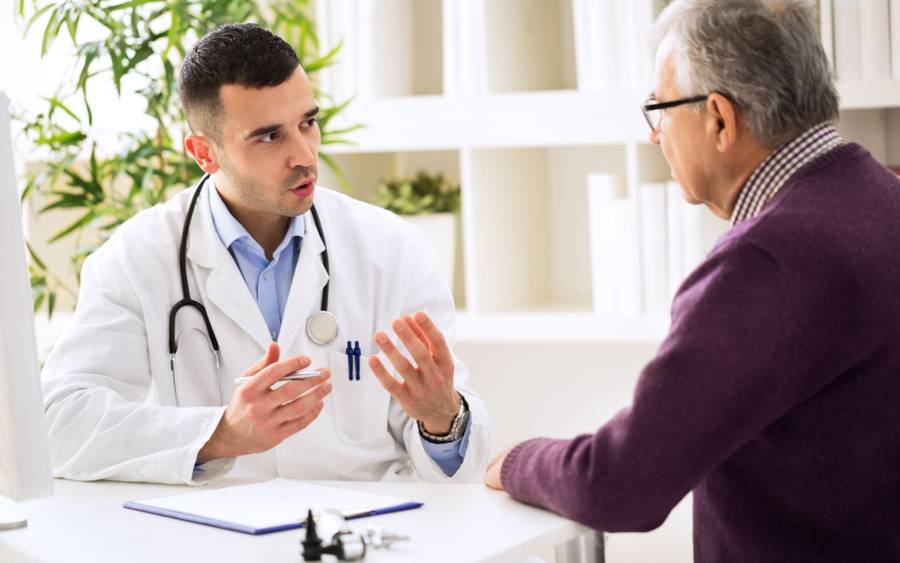 A vascular surgeon discusses treatment plans with an aortic aneurysm patient.