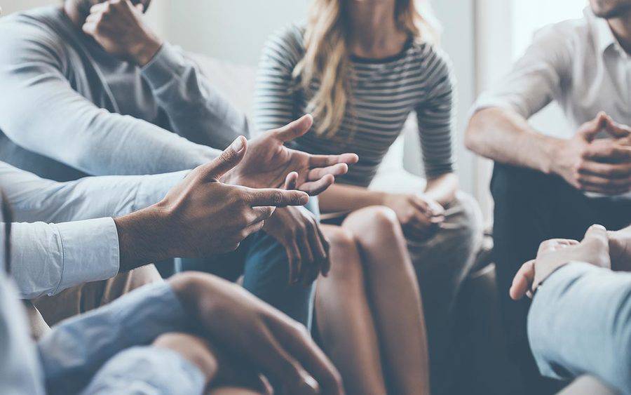 A man talks to a support group, representing people with aphasia practicing their communication skills in a supportive environment. 