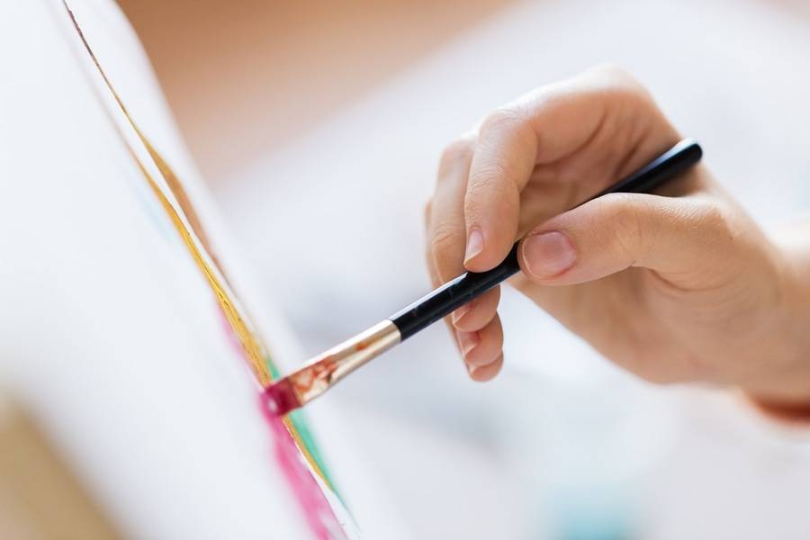 Hand holding a paint brush.