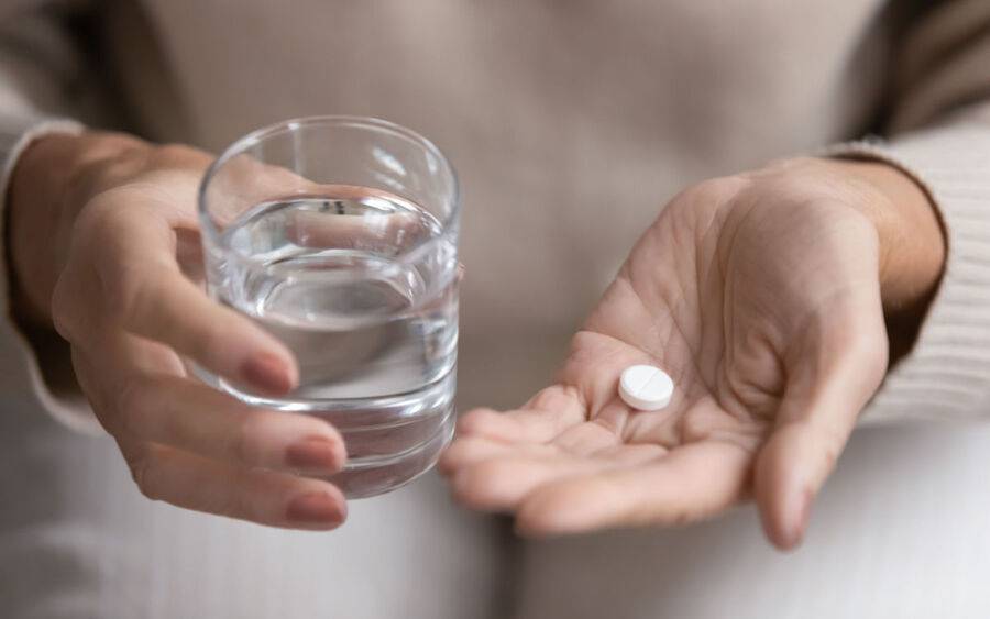 Patient holds an aspirin to help lower his risk of heart disease or stroke.