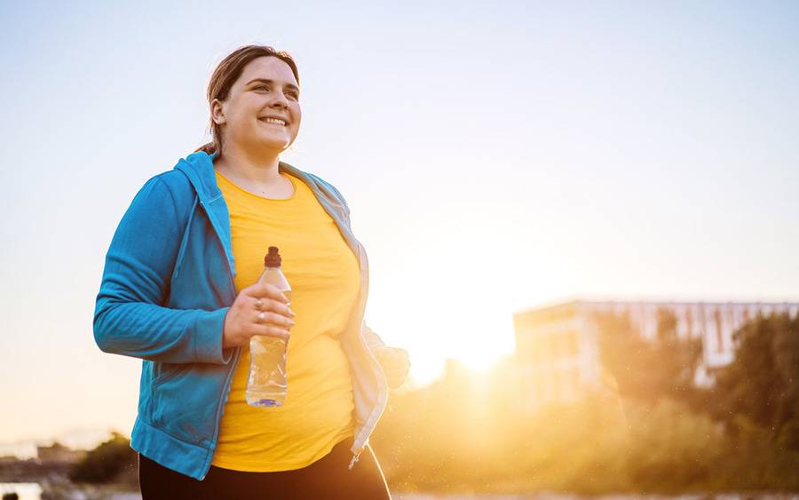 A young woman jogs in the early morning light, representing a healthy lifestyle reinforced by a support group. 