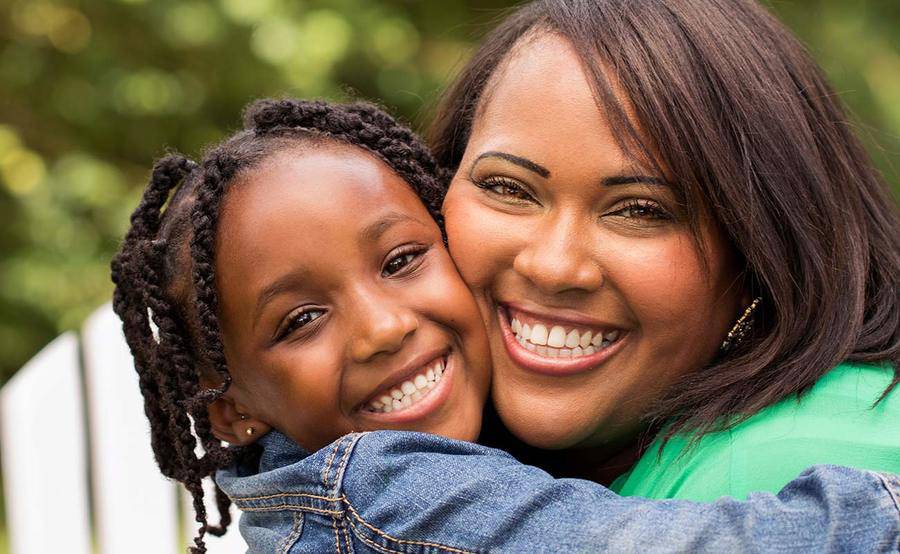 A mother and child smiling while hugging, representing the full life that can be led after bariatric surgery for weight loss.