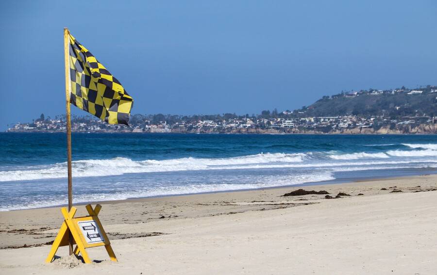 A stretch of beach with safety signs.