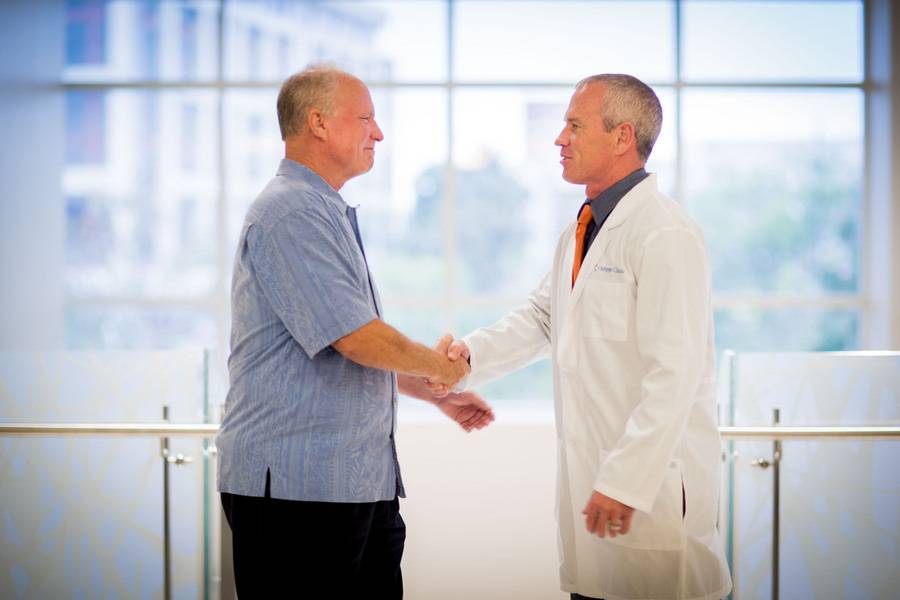 Scripps Clinic cardiologist Douglas Gibson, MD, and a patient shake hands while discussing heart care.
