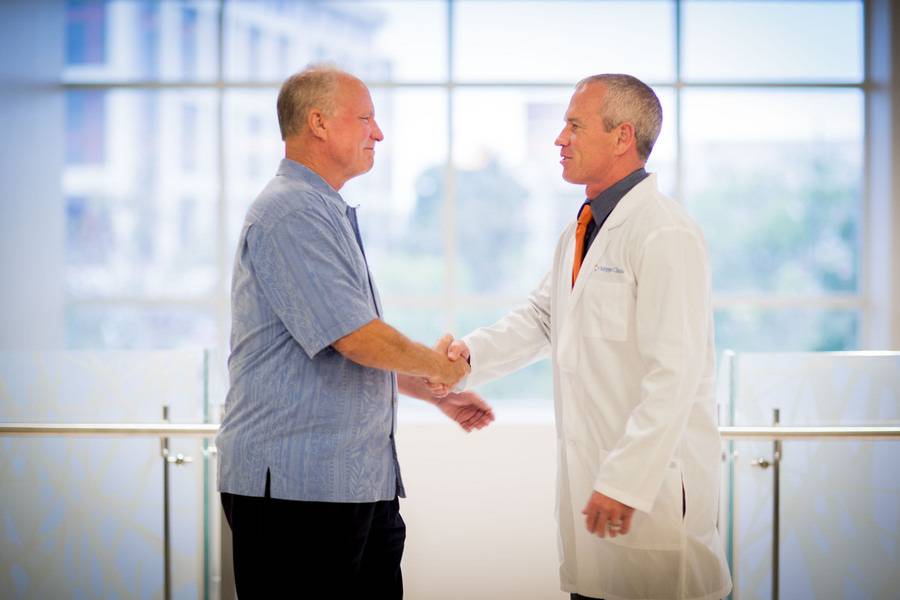 Scripps Clinic cardiologist Douglas Gibson, MD, and a patient shake hands while discussing heart care.
