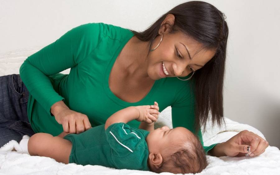 A happy mom plays with her baby.