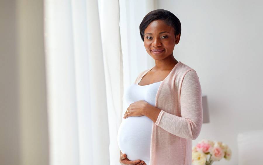 A pregnant African-American woman raising awareness about Black Maternal Health Week in April