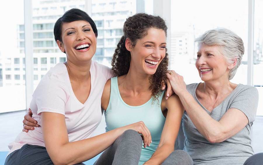 Three smiling women sit in a yoga studio, representing the active life that can be enjoyed after bladder symptoms are under control.