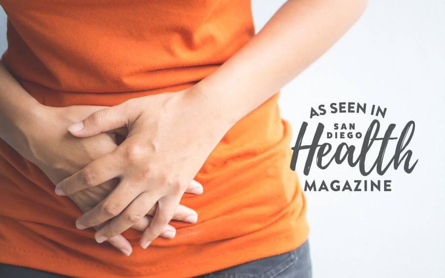 A woman presses her hands against her lower abdomen, showing how urinary tract infections and interstitial cystitis can cause pain and other bladder problems. 