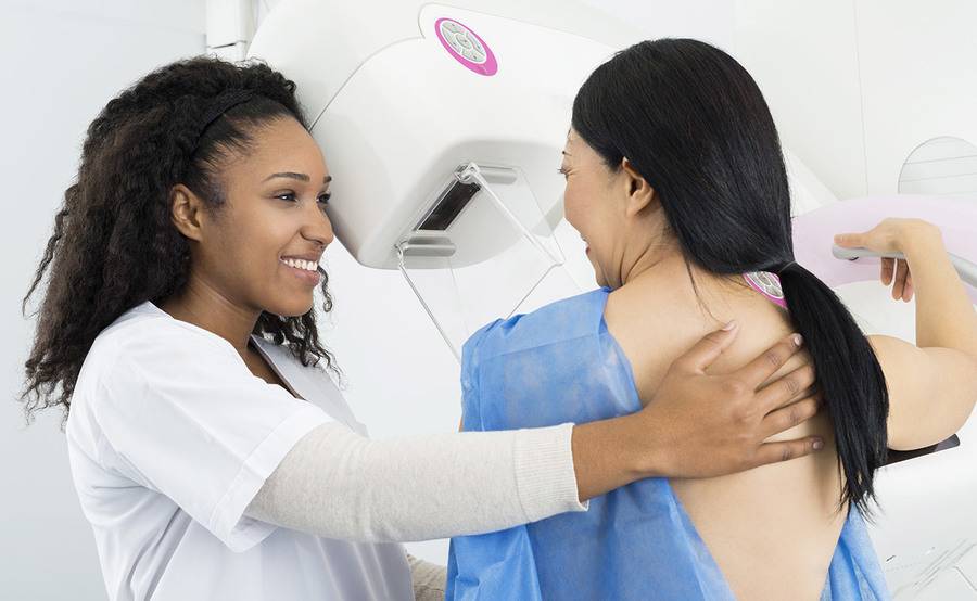 A middle-aged Asian woman gets a mammogram to detect breast cancer.
