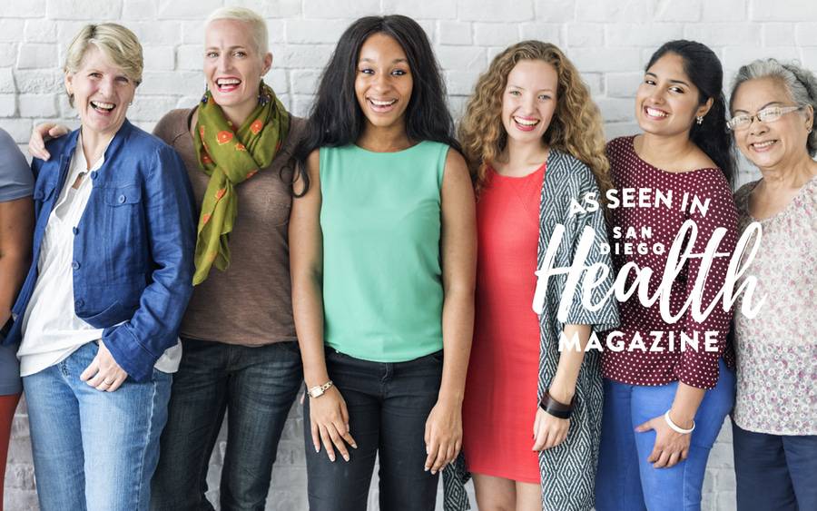 A group of women gather for a photo to highlight the importance of breast self-exams.
