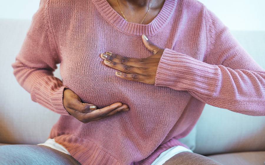 A woman gives herself a breast self exam.