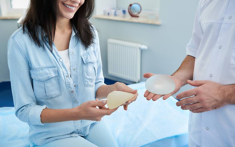 A woman discusses breast implant revision with her doctor.