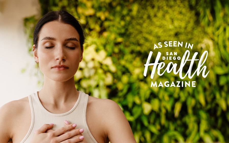 A woman places her hands over her heart in a sitting position with her eyes closed as she concentrates on her breathing, which can help boost physical and mental health. - SD Health Magazine