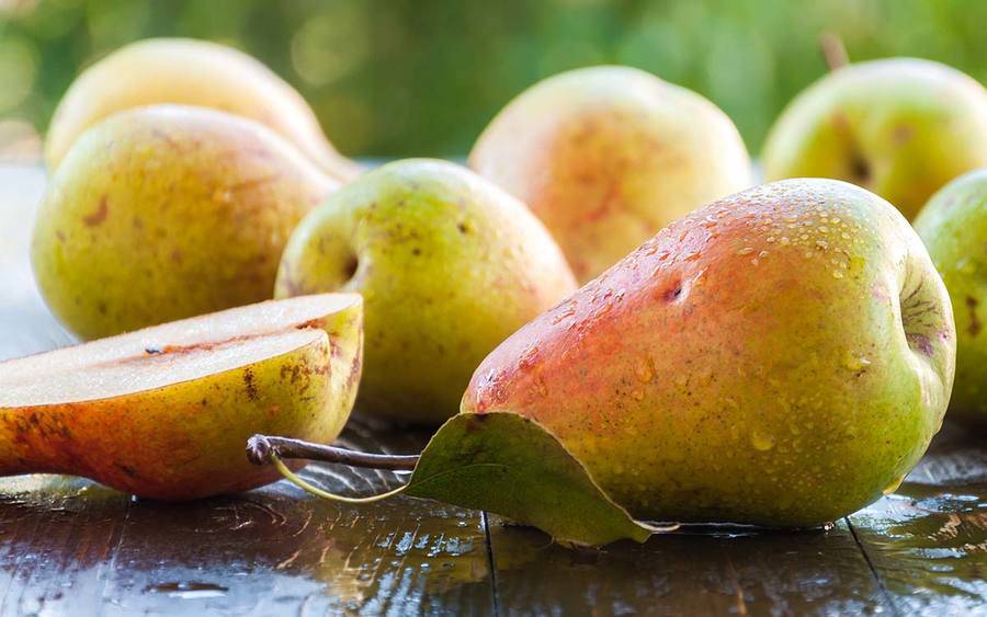 A group of fresh pears represents how adding fruits to your diet may help prevent cancer.