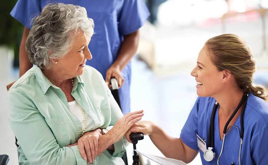 A female nurse greets a mature woman in a wheelchair, representing how Scripps helps you through your cancer journey.