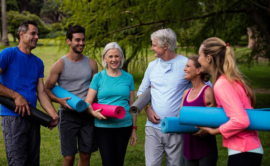 Cancer patients and survivors gather outdoors for a yoga class.