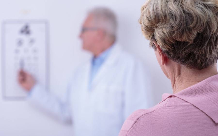 An eye chart appears fuzzy to a woman who is testing for cataracts.