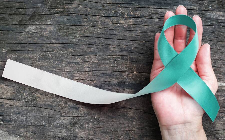 Woman holding cervical cancer awareness symbol.