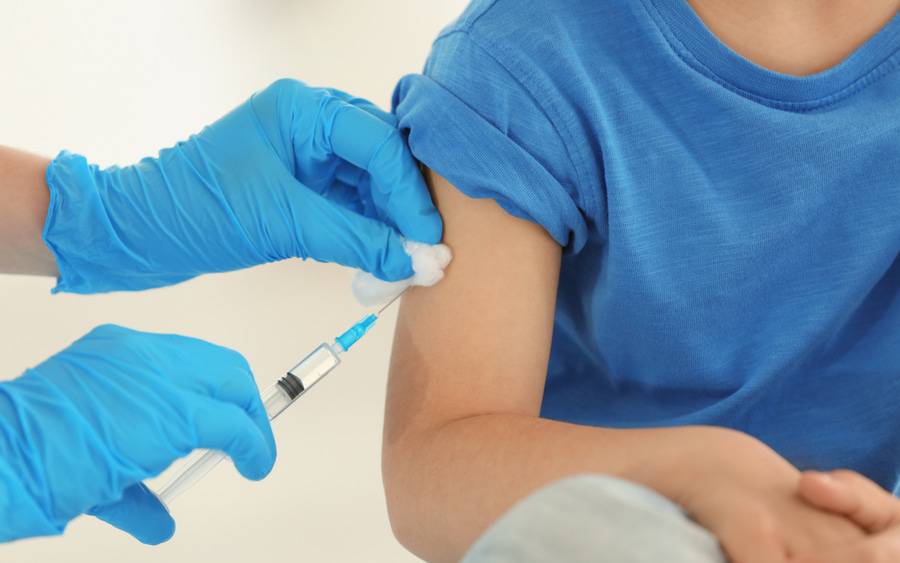 Nurse gives child vaccination.