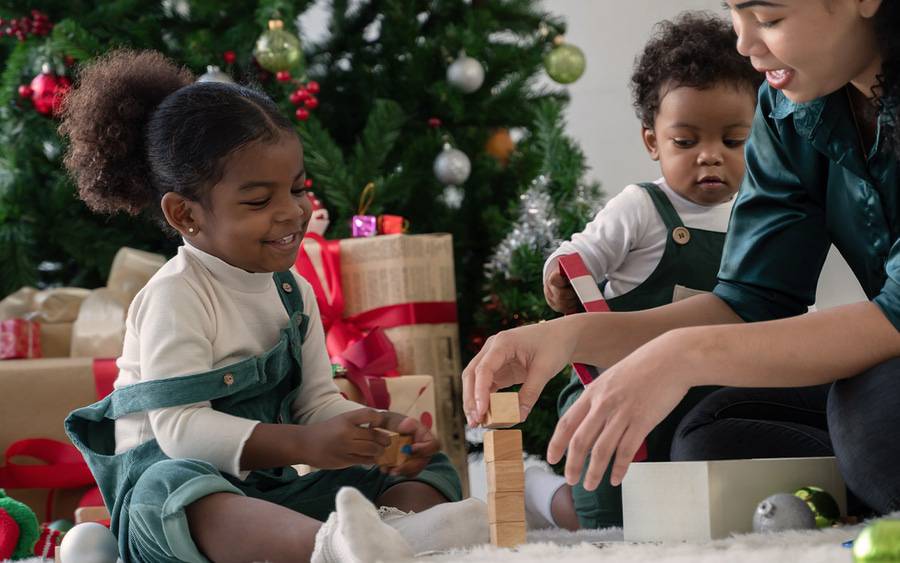 Young children play with newly opened Christmas gifts.
