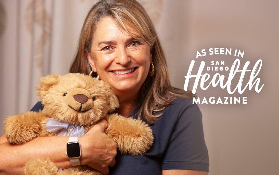 A woman hugs a therapy teddy bear comfort cub, which helps adults ease loss of loved ones. SD Health Magazine