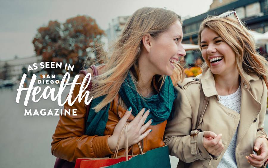 Two women shopping and having fun, showing how to keep your holidays saeason joyful.