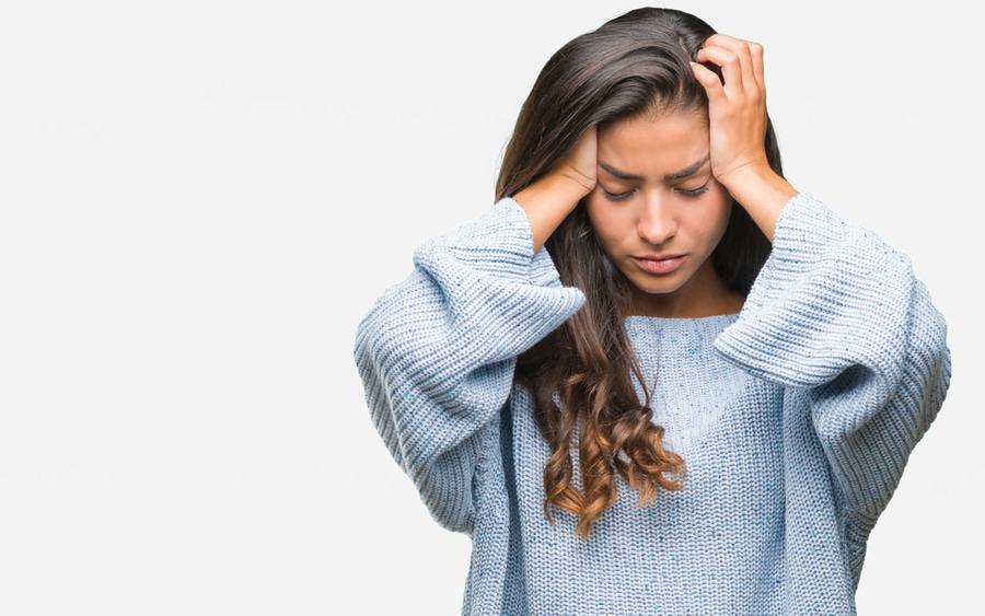 Woman holding her head in pain from a headache.