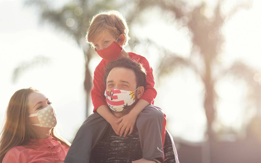 Mother, father, son wearing masks to protect from COVID-19