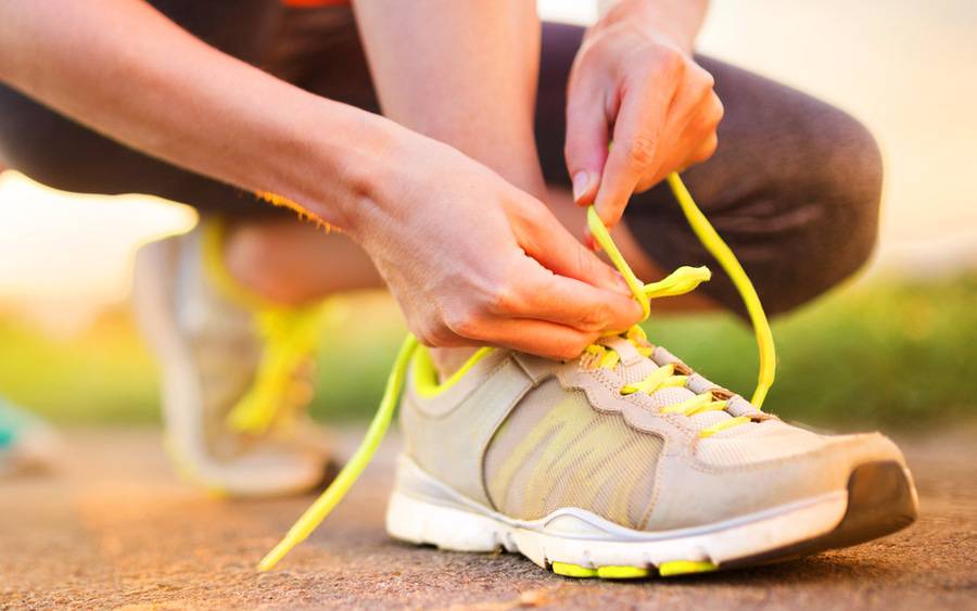 Beginning runner ties running shoes during pandemic.