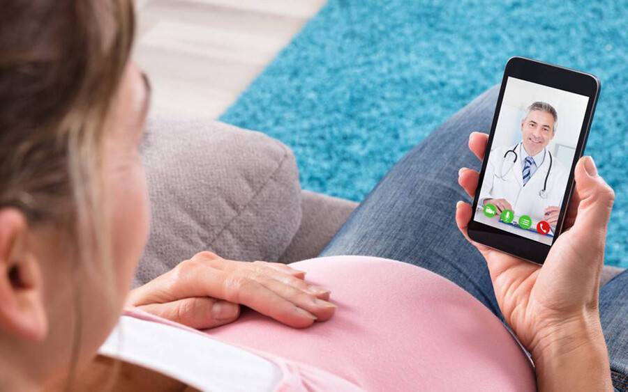 A woman having a video visit with her physician from the safety from her home.