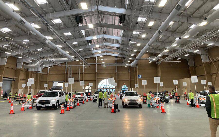 Patients drive up in six lanes to get a COVID-19 vaccine inside a large hangar at the Del Mar Fairgrounds in San Diego.