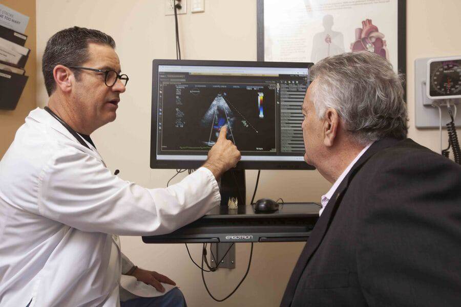 Curtiss Stinis, MD, Scripps Clinic, talks with John Rufo as he explains treatment looking at heart imaging on a computer screen.
